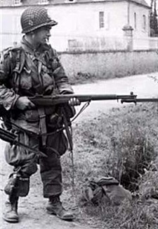 Een Amerikaanse para houd een Duitser onder schot, net buiten Sainte-Mère-Eglise. Moeilijkheden met het afbeeldingsformaat beletten de ganse foto te tonen.